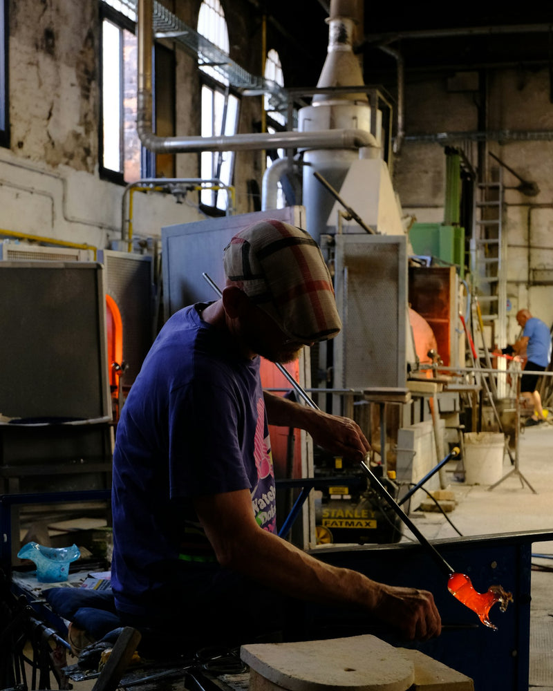 A Murano glassblower shaping glass in Venice